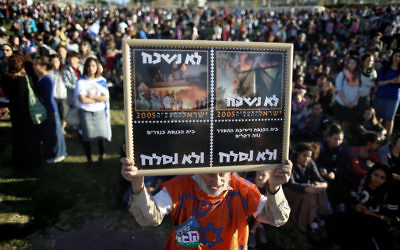 Un homme brandissant une pancarte qui lit "Nous n'oublions pas, nous ne pardonnerons pas" lors de la marche dans la zone E1 près de l'implantation Maale Adumim, le 13 février 2014 (Crédit : Yonathan Sindel/Flash 90)
