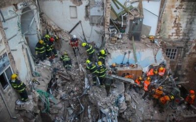 Le personnel de secrours dans les décombres à Acre (Crédit : Avishag Shaar Yashuv/Flash90)