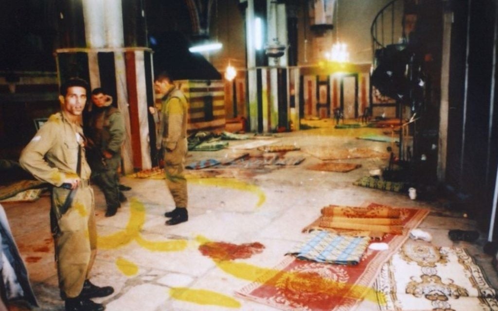 Des soldats israéliens se tiennent à côté des taches de sang au sol du hall de Yitzhak, au tombeau des Patriarches, connu en arabe sous le nom d'Al-Haram Al-Ibrahimi, suite au massacre de Goldstein, le 25 fevrier 1994 (Crédit : Flash90)