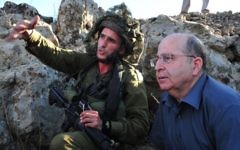 Le ministre de la Défense Moshe Yaalon (à droite) et un soldat lors d'une visite pendant un exercice de la brigade d’infanterie parachutiste sur le plateau du Golan - 2 octobre 2013 (Crédit : Ariel Hermoni/Ministère de la Défense)