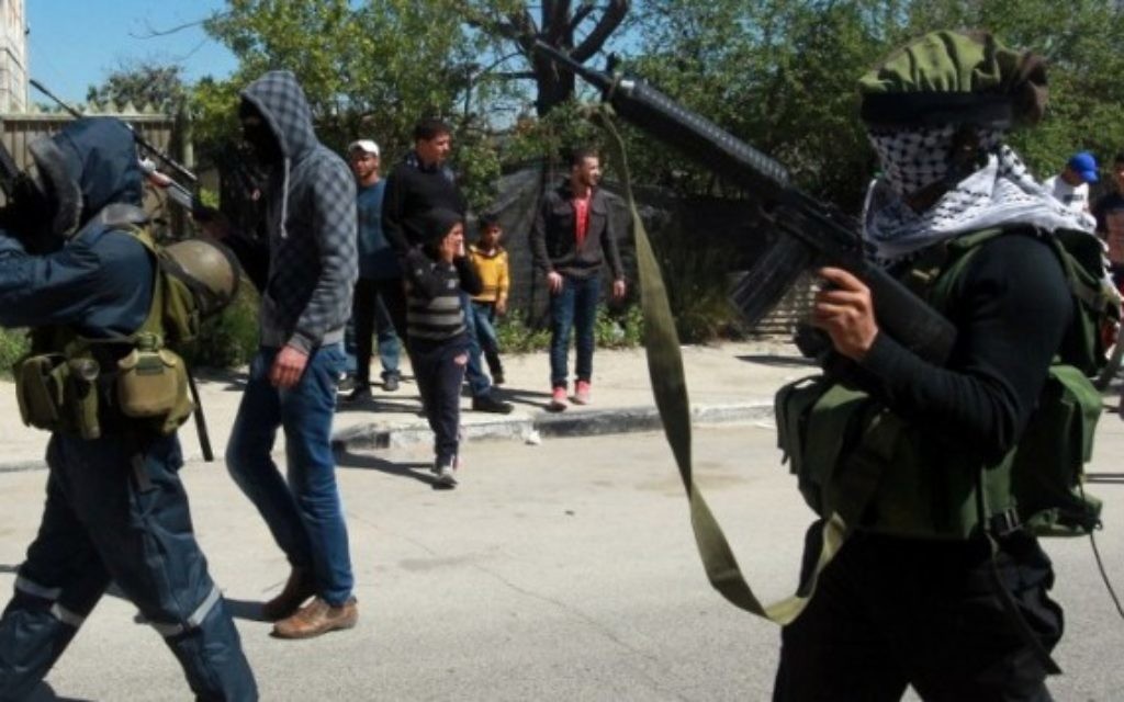Des hommes armés assistent aux funérailles des trois Palestiniens tués lors d'un raid israélien dans la ville de Jénine en Cisjordanie, le 22 mars 2014 (Crédit : Jaafar Ashtiyeh/AFP) Des hommes armés assistent aux funérailles des trois Palestiniens tués lors d'un raid israélien dans la ville de Jénine en Cisjordanie, le 22 mars 2014 (Crédit : Jaafar Ashtiyeh/AFP)