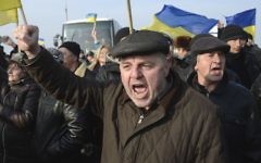 Des Ukrainiens manifestent au poste de contrôle qui bloque l'entrée en Crimée, le 7 mars 2014 (Crédit : Alexander Nemenov/AFP)