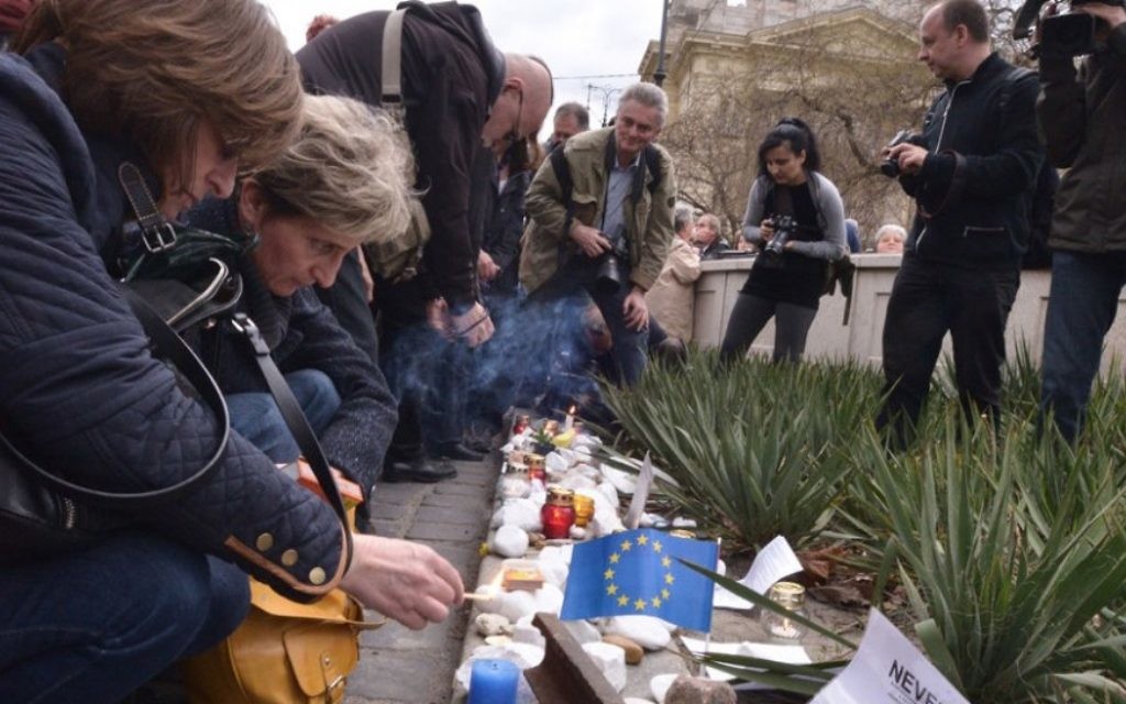 Des manifestants allument des bougies à un rassemblement à Budapest pour protester contre un projet de loi visant à faire de la Hongrie une victime de l'Occupation (Crédit : Cnaan Liphshiz/JTA) Des manifestants allument des bougies à un rassemblement à Budapest pour protester contre un projet de loi visant à faire de la Hongrie une victime de l'Occupation (Crédit : Cnaan Liphshiz/JTA)