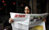 Lectrice du quotidien Maariv (Crédit : Miriam Alster/Flash 90)