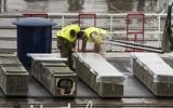 Les forces de sécurité israéliennes inspectent les boites de roquettes M-302, déchargées du navire Klos-C, le 9 mars 2014 au port d'Eilat (Crédit : Jack Guez/AFP)