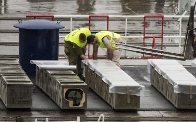 Les forces de sécurité israéliennes inspectent les boites de roquettes M-302, déchargées du navire Klos-C, le 9 mars 2014 au port d'Eilat (Crédit : Jack Guez/AFP)