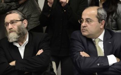 Le député arabe israélien Ahmed Tibi (à droite) assis aux côtés de Moshe Gafni à un meeting de l'opposition à la Knesset (Crédit : Tomer Neuberg/Flash90)