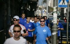 Nir Barkat, le maire de Jérusalem, au milieu des coureurs, s'échauffe pour le marathon de Jérusalem, en mars 2014. (Crédit : Flash 90)