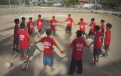 Des enfants jouant au football sur l'île de Bantanyan avec un éducateur de l'ONG israélienne Mifalot (Crédit : capture d'écran YouTube)