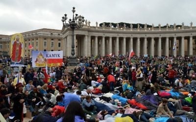 Des fidèles au Vatican en train d'attendre les cérémonies de canonisation de Jean XXIII et Jean-Paul II (Crédit : Alberto Pizzoli/AFP)