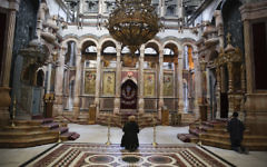 Une chrétienne prie à l'Église du Saint Sépulcre dans la Vieille Ville de Jérusalem, le 14 janvier 2014 (Crédit : Nati Shohat/Flash 90)