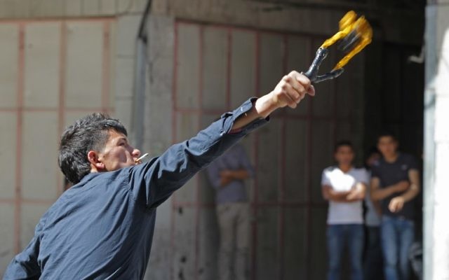 Un émeutier qui lance un cocktail Molotov (Crédit : Hazem Bader/AFP) Un émeutier qui lance un cocktail Molotov (Crédit : Hazem Bader/AFP)