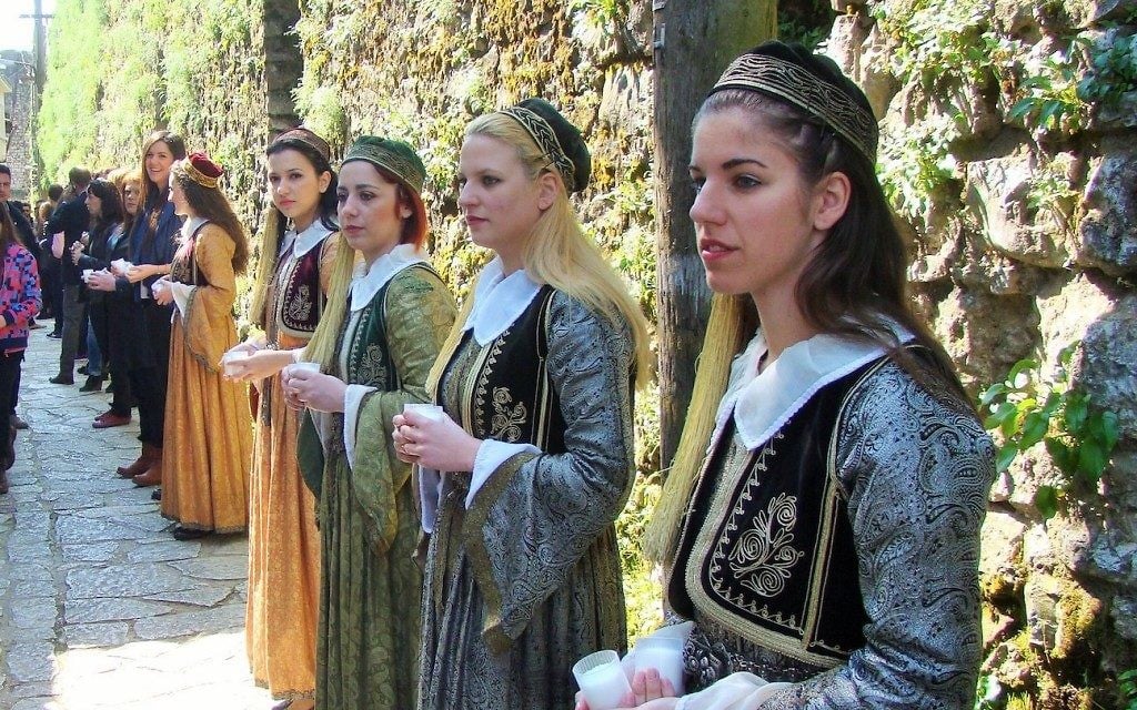 Des jeunes de la communauté juive de Ioannina, vêtu de robes traditionnelles, tiennent des bougies allumées à la mémoire des 500 enfants déportés à Auschwitz (Crédit : Gavin Rabinowitz/JTA)