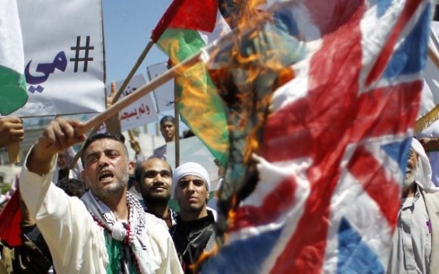 Des Palestiniens brûlent des drapeaux israéliens et britanniques lors du 66ème rassemblement pour la Nakba à Rafah - 14 mai 2014 (Crédit : Said Khatib/AFP)
