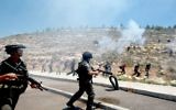 Gardes-frontières israéliens pendant des affrontements contre des manifestants palestiniens commémorant le 66e anniversaire de la "Nakba" dans le village de Walajah, en Cisjordanie, au sud de Jérusalem, le 15 mai 2014. (Crédit : Musa al-Shaer/AFP)