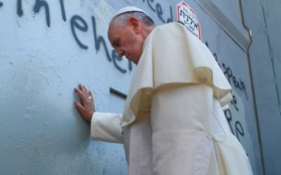Le pape fait une prière devant la barrière de sécurité (Crédit : AFP)
