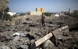 Un Palestinien marchant sur des ruines après un raid israélien (Crédit : AFP/MOHAMMED ABED)