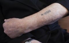 Un survivant de la Shoah montre son bras tatoué par les nazis. Illustration. (Crédit : Yonatan Sindel/Flash90)
