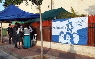 Un drapeau à l'effigie des trois adolescents kidnappés devant le domicile des parents de Eyal Yifrach (Crédit: Gideon Markowicz/Flash90)