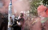 Un manifestant français à Paris qui fait une quenelle en portant un masque et une fausse roquette - 13 juillet 2014 (Crédit : AFP)