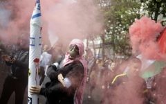 Un manifestant français à Paris qui fait une quenelle en portant un masque et une fausse roquette - 13 juillet 2014 (Crédit : AFP)