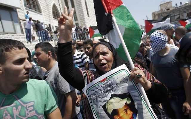 Des manifestants palestiniens escortent le corps du jeune Mohammad Abou Khdeir (Crédit : AFP/Thomas Coex)