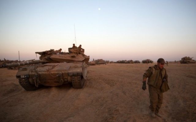 Un soldat israélien et un char déployés près de la frontière avec Gaza (Crédit : Menahem Kahana/AFP) Un soldat israélien et un char déployés près de la frontière avec Gaza (Crédit : Menahem Kahana/AFP)