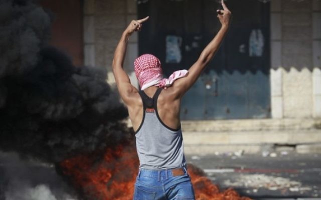 Un activiste palestinien lance des pierres à la police israélienne à Shuafat - 2 juillet 2014 (Crédit : Hadas Parush/Flash90)