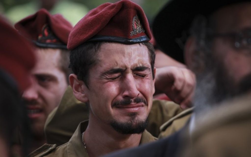 Soldat à l'enterrement du sergent Benaya Rubel, au cimetière militaire de Holon, le 20 juillet 2014. Le parachutiste de 20 ans a été tué par des hommes armés du Hamas à Gaza, le deuxième jour de l'opération de Bordure protectrice. (Crédit : Hadas Parush/Flash90) Soldat à l'enterrement du sergent Benaya Rubel, au cimetière militaire de Holon, le 20 juillet 2014. Le parachutiste de 20 ans a été tué par des hommes armés du Hamas à Gaza, le deuxième jour de l'opération de Bordure protectrice. (Crédit : Hadas Parush/Flash90)