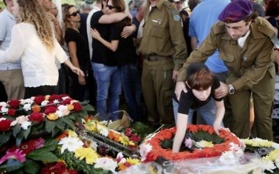 Le fils du Major Amotz Greenberg (rés.), 45, vu sur la tombe de son père lors de l'enterrement au cimetière militaire à Hod Hasharon, le dimanche 20 juillet 2014. Greenberg a été tué par des terroristes du Hamas sortis d'un tunnel en Israël et ont ouvert le feu sur son véhicule de l'armée le 19 juillet (Crédit : Miriam Alster/Flash90).