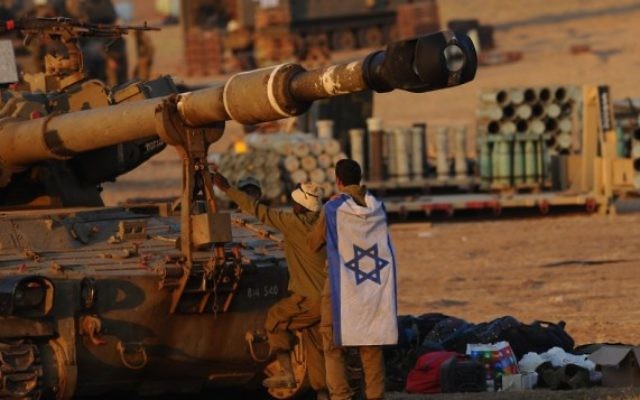 Des soldats israéliens près d'un char d'artillerie dans la bande de Gaza (Crédit : Mendy Hechtman/Flash90)