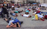 Les gens dans une place principale à Vienne se mettent à couvert pendant un flash mob simulant une attaque de missiles du Hamas le 24 juillet 2014. (Crédit : capture d'écran YouTube)