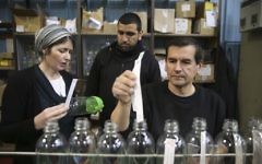 Un ouvrier palestinien et un employé juif de SodaStream dans l'usine du parc industriel de Mishor Adumim, le 2 février 2014. (Crédit : Nati Shohat/Flash90)