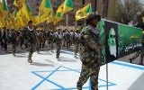 Photo d'illustration: Des terroristes du Kataeb Hezbollah tiennent les drapeaux jaunes de la branche irakienne du groupe chiite et un portrait de guide spirituel de l'Iran, l'ayatollah Ruhollah Khomeini, et marchent sur ​​un drapeau israélien peint sur ​​le sol pendant la journée d'al-Qods (Jérusalem), à Bagdad, le 25 Juillet 2014. (Crédit : AFP / Ali Al-Saadi)