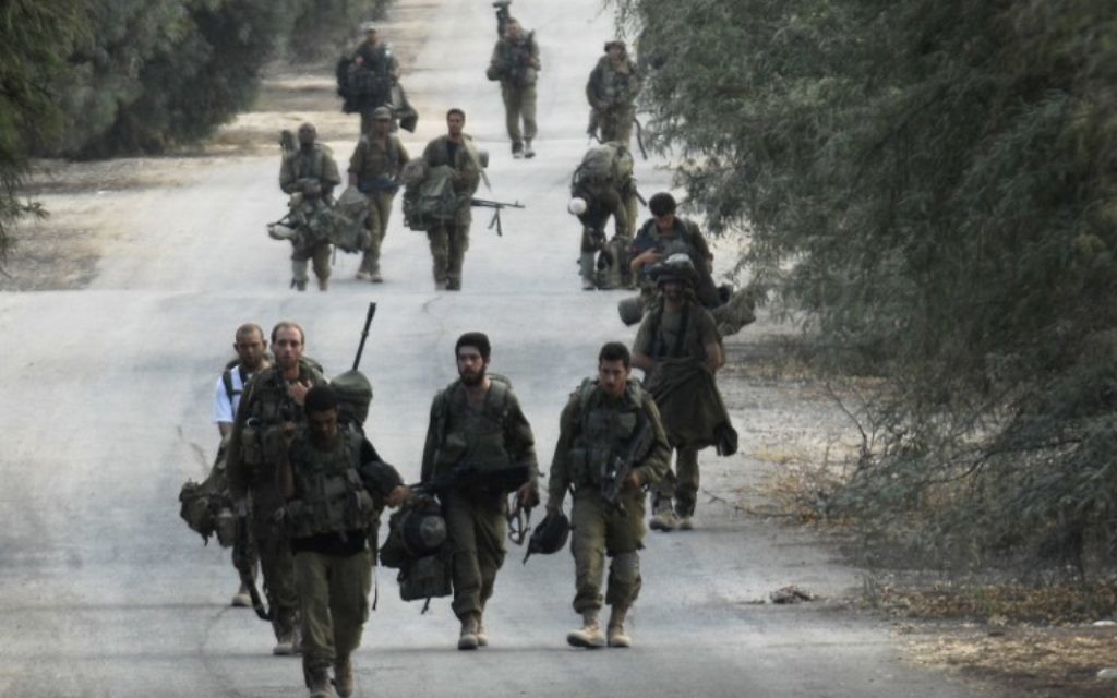 Soldats israéliens à pied près de la frontière entre Israël et la bande de Gaza qui reviennent de l'enclave côtière palestinienne contrôlée par le Hamas, le mardi 5 août 2014 (Crédit : AFP / DAVID BUIMOVITCH) Soldats israéliens à pied près de la frontière entre Israël et la bande de Gaza qui reviennent de l'enclave côtière palestinienne contrôlée par le Hamas, le mardi 5 août 2014 (Crédit : AFP / DAVID BUIMOVITCH)
