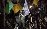 Un militant brandit son arme alors qu'il tire des coups de feu en l'air après avoir rejoint des centaines d'habitants de Gaza, le 26 août 2014 pour célébrer un accord de cessez-le-feu conclu entre Israël et le Hamas. (Crédit : AFP PHOTO / ROBERTO SCHMIDT)