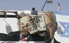 Des ouvriers remplaçant une affiche de campagne du Parti travailliste avec une du Likud à Jérusalem, le 30 janvier 2009 (Crédit : Yossi Zamir / Flash90)