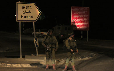 Des soldats israéliens devant l'entrée du village Hussan (Crédit : Oren Nahshon / Flash90)