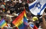 Des drapeaux gays et israéliens à la parade annuelle à Tel Aviv (Crédit : Miriam Alster/Flash90)
