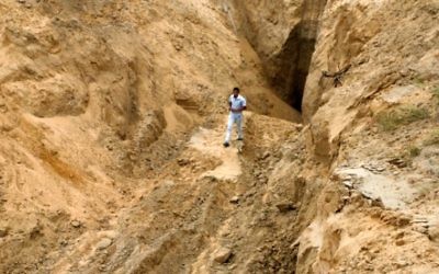 Un Palestinien se penche sur ce qui était autrefois un tunnel menant de la bande de Gaza vers Israël, dans la région de Rafah, dans le sud de la bande de Gaza, le 5 août 2014, après une trêve de 72 heures (Crédit : Abed Rahim Khatib / Flash90)