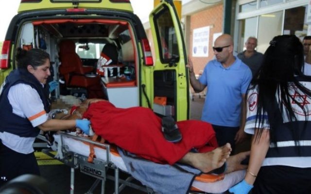 Un homme blessé par un tir de mortier est évacué à l'hôpital Barzilai d'Ashkelon (Crédit: Edi Israel/Flash90)