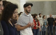 Un groupe de participants récite les prières de deuil en Hébreu et en Arabe au camp de Mauthausen (Crédit : Daniel Shaked)
