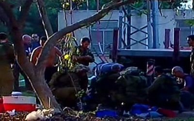 Les premiers intervenants et les soldats de Tsahal sur la scène d'un barrage de mortier dans le kibbutz Nirim dans la région d'Eshkol. (Crédit : capture d'écran Deuxième chaîne)