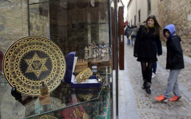 Illustration : Des personnes se tenant près d’une boutique de souvenirs, dans l’ancien quartier juif de Tolède, en Espagne, le 27 février 2014. (Crédit : Gerard Julien/AFP)
