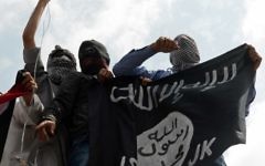Des manifestants tiennent un drapeau de l'Etat islamique lors d'une protestation contre Israël, au centre de Srinagar, à Cachemire - le 18 juillet 2014 (Crédit : AFP / Tauseef MUSTAFA)