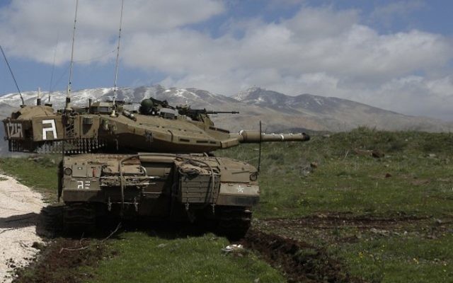 Un tank israélien stationné près du village de Majdal Shams, situé près du plateau du Golan - 19 mars 2014 (Crédit : AFP/Jalaa Marey) Un tank israélien stationné près du village de Majdal Shams, situé près du plateau du Golan - 19 mars 2014 (Crédit : AFP/Jalaa Marey)