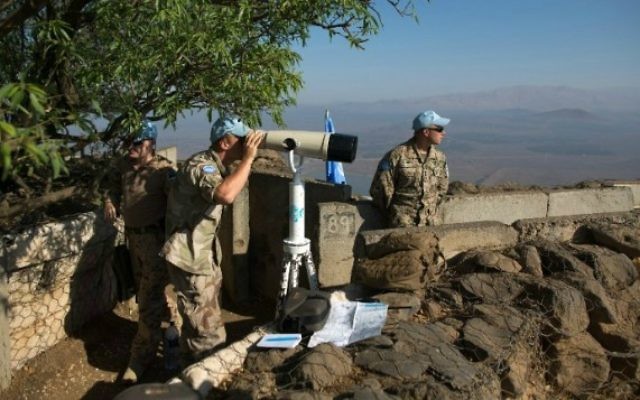 Les soldats de la FNUOD, la Force des Nations Unies chargée d'observer le désengagement, observent le plateau du Golan israélien, le 31 août 2014. (Crédit : Menahem Kahana/AFP) Les soldats de la FNUOD, la Force des Nations Unies chargée d'observer le désengagement, observent le plateau du Golan israélien, le 31 août 2014. (Crédit : Menahem Kahana/AFP)