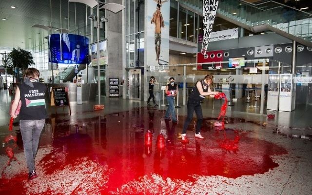 Belgique : Des féministes déversent du faux sang dans un aéroport pour protester contre le "transport d’armes vers Israël" - 26 ao^t 2014 (Crédit : AFP / BELGA / NICOLAS LAMBERT) Belgique : Des féministes déversent du faux sang dans un aéroport pour protester contre le "transport d’armes vers Israël" - 26 ao^t 2014 (Crédit : AFP / BELGA / NICOLAS LAMBERT)