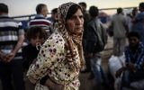 Une réfugiée kurde syrienne tient un bébé après avoir franchi la frontière près de la ville sud-est de la province de Sanliurfa Suruc, le 21 septembre, 2014 (Crédit : AFP PHOTO / BULENT KILIC)