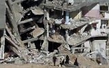 Une famille passe devant les ruines d'immeubles à Shejaiya, dans la bande de Gaza, le 27 août 2014. (Crédit : AFP/Roberto Schmidt)